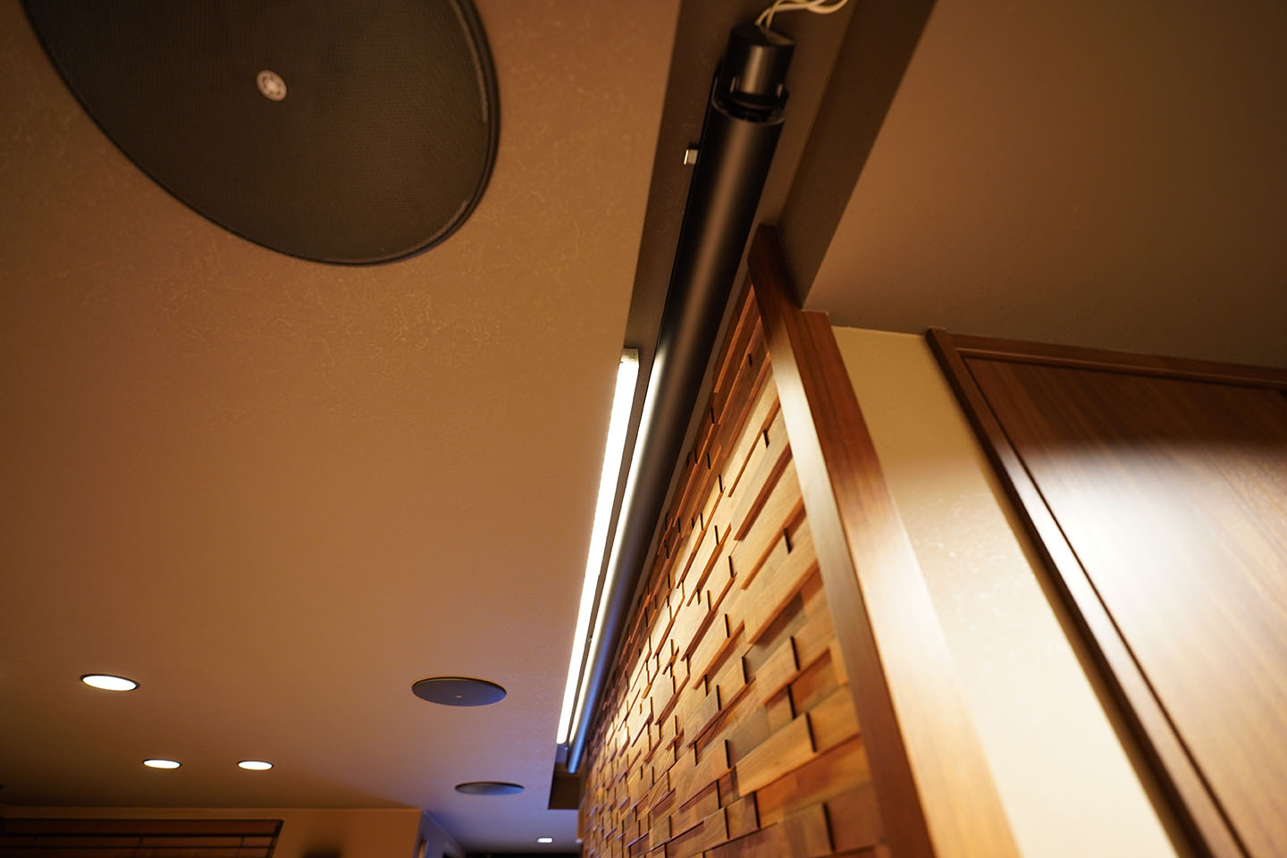 天井を彫り込んで電動スクリーンを隠すと同時に間接照明を設置